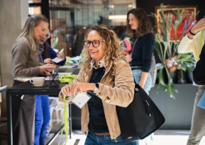 Teilnehmerin lacht beim Check-in der Staging Connect
