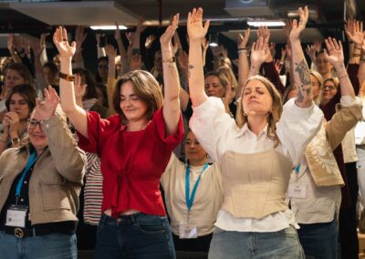 Teilnehmerinnen mit erhobenen Armen beim Breathwork